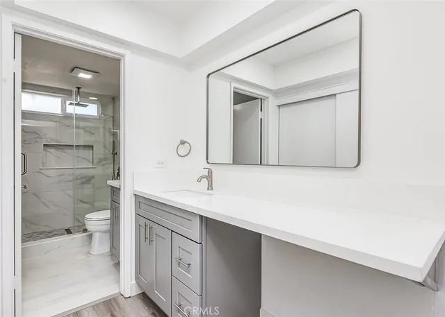 a bathroom with a sink a toilet and shower