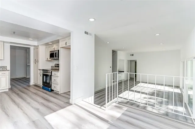 a view of a hallway with wooden floor and a living room