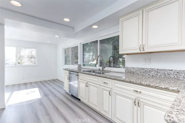 a kitchen with stainless steel appliances granite countertop a sink and dishwasher with wooden floor