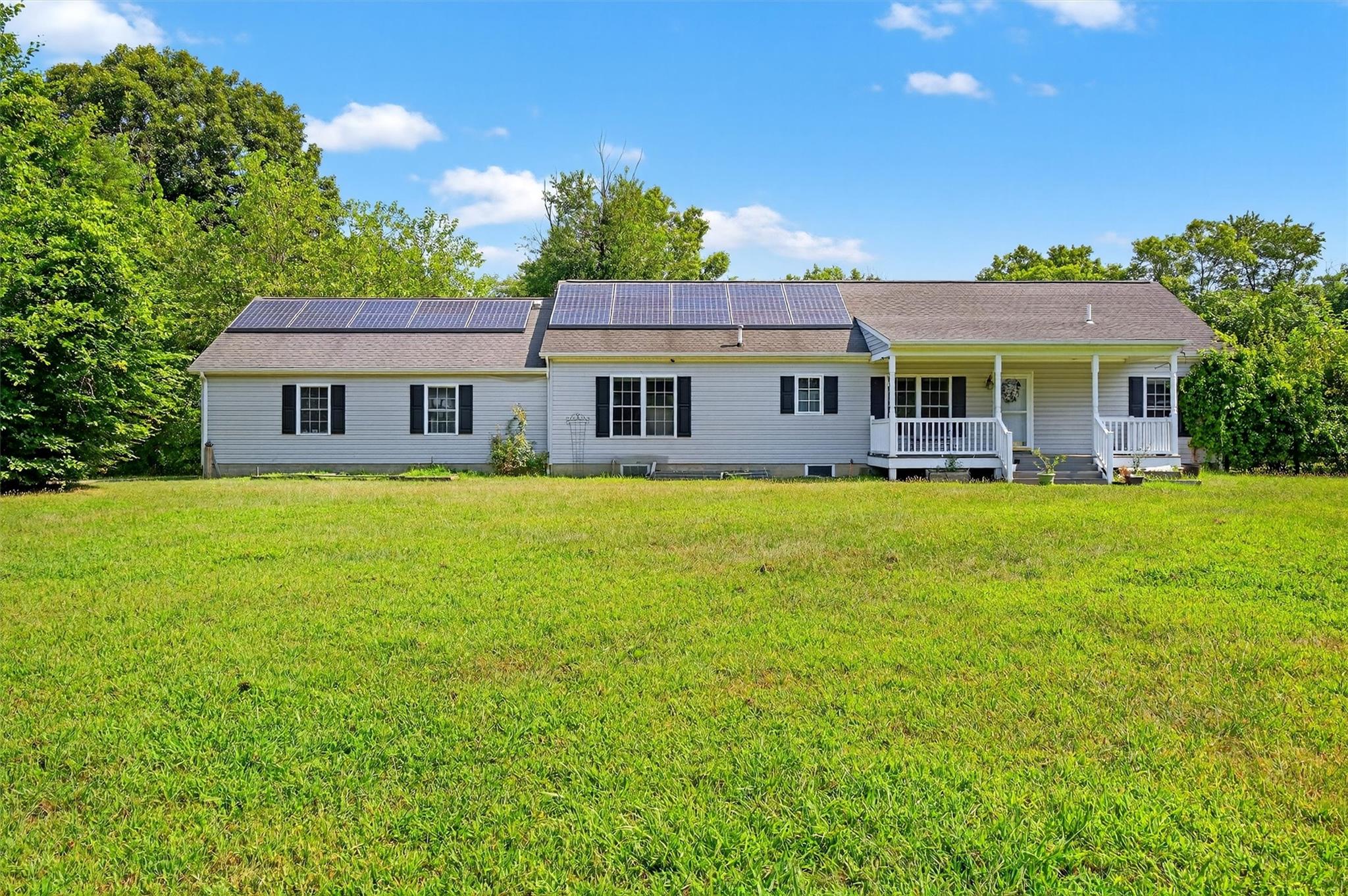 89 Widmer Road Wappingers Falls, NY 12590 - Photo 1 of 1 Front view of house with covered porch, roof mounted solar panels, and a yard
