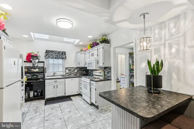 a kitchen with granite countertop a sink stove and cabinets