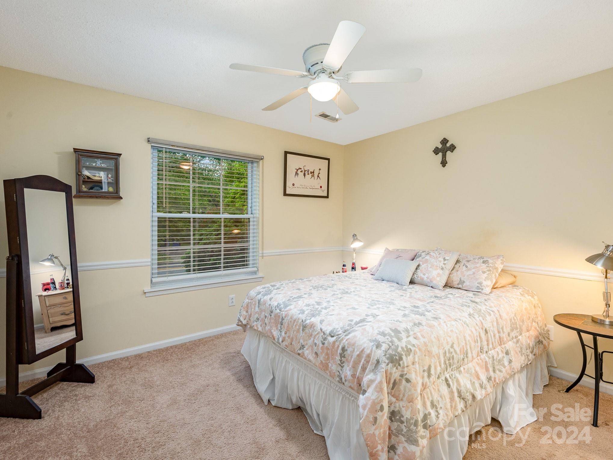 11625 Park Road Charlotte, NC 28226 - Photo 13 of 28 a bedroom with a bed next to a window with a chandelier