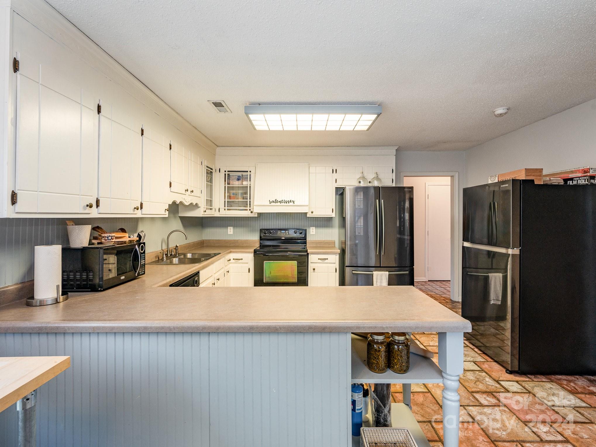 11625 Park Road Charlotte, NC 28226 - Photo 16 of 28 a kitchen with refrigerator and chairs