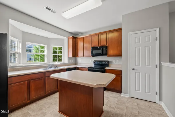 a kitchen with stainless steel appliances granite countertop a sink stove microwave and window