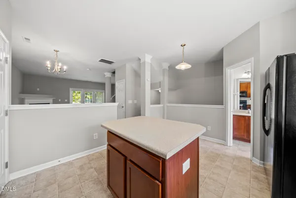 a kitchen that has a kitchen island wooden cabinets and refrigerator