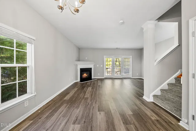 a view of empty room with wooden floor and fireplace