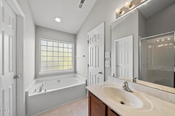 a bathroom with a tub sink double and mirror