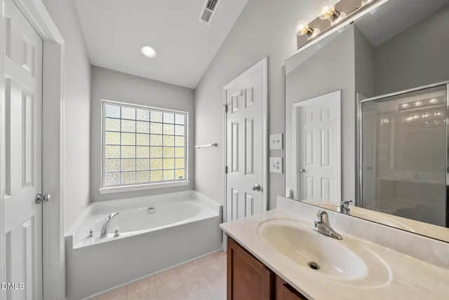 a bathroom with a tub sink double and mirror