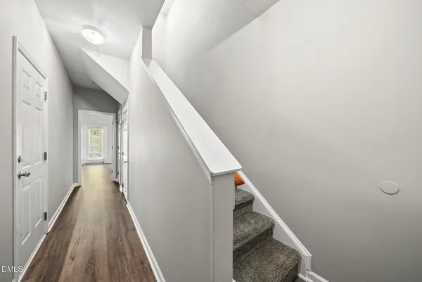 a view of a hallway with wooden floor and stairs