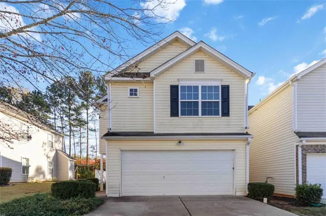 a view of small house with garage