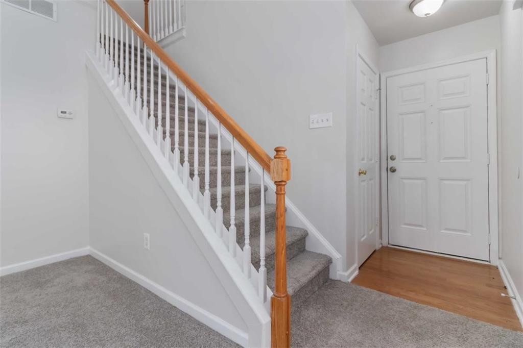 6265 Smoke Ridge Lane Cumming, GA 30041 - Photo 5 of 33 a view of staircase with wooden floor and white walls