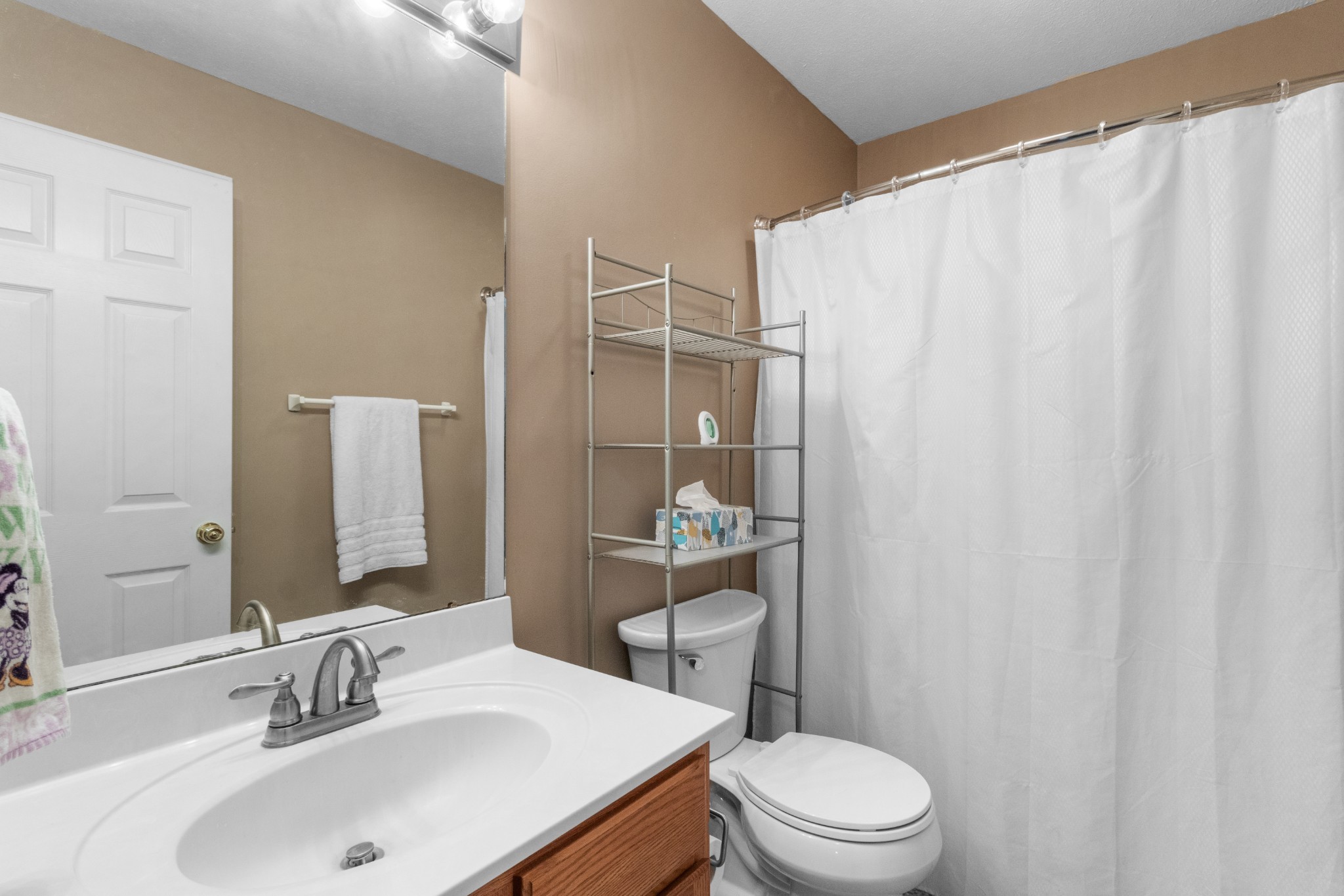 1033 Sivley Road Hopkinsville, KY 42240 - Photo 23 of 23 a bathroom with a sink a toilet and shower curtain