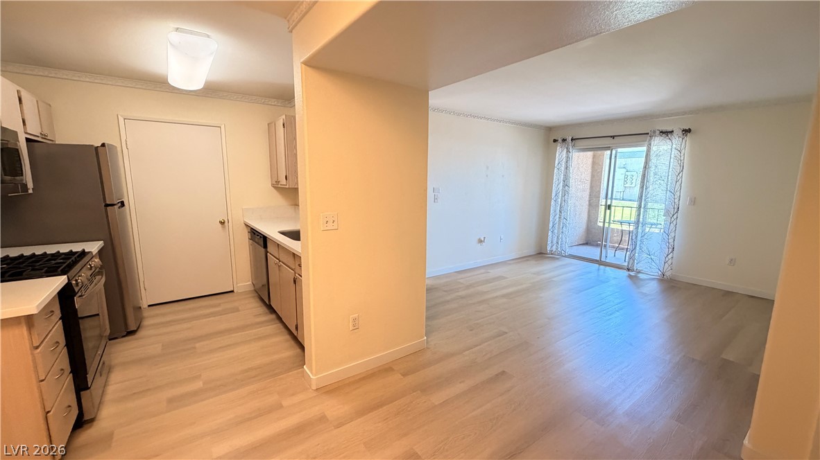 7885 West Flamingo Road, Unit 1131 Las Vegas, NV 89147 - Photo 32 of 36 A well-lit living area with durable flooring flows seamlessly to a private balcony, perfect for morning coffee.