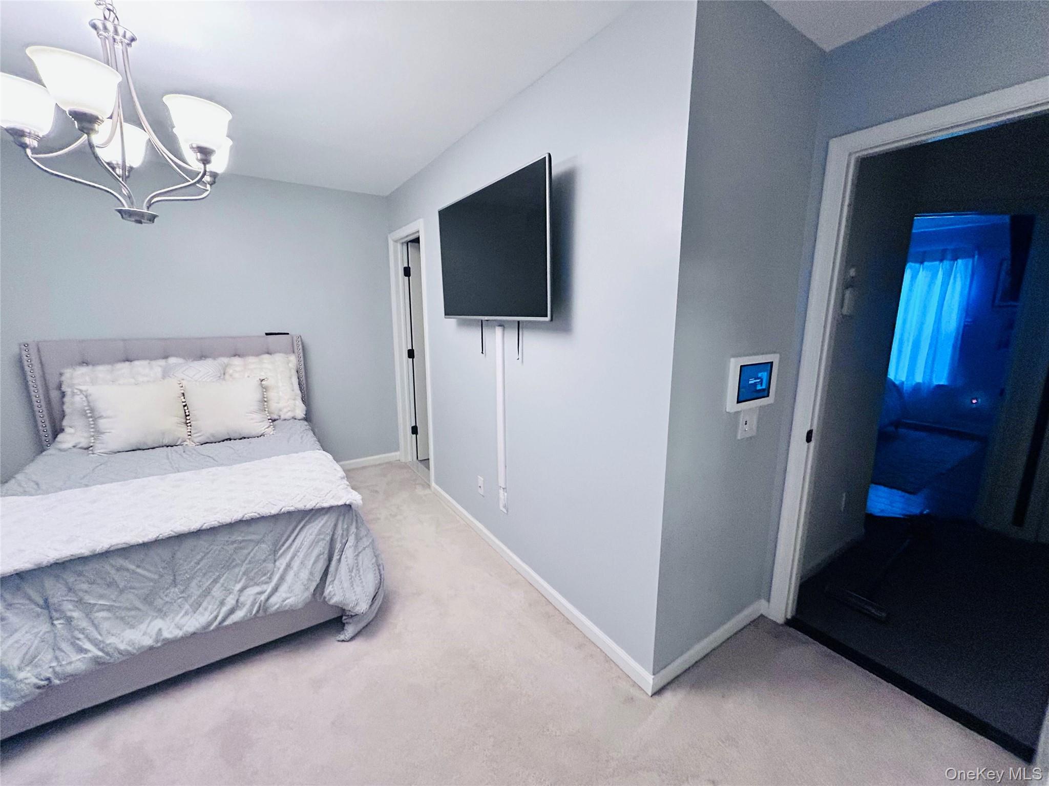 58 Rialto Way Patchogue, NY 11772 - Photo 38 of 40 a spacious bedroom with a bed and a flat screen tv