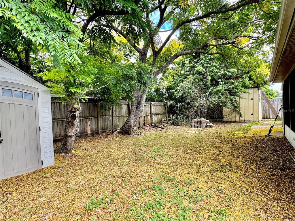 7235 Potomac Drive Port Richey, FL 34668 - Photo 22 of 23 a backyard of a house with a large tree and wooden fence