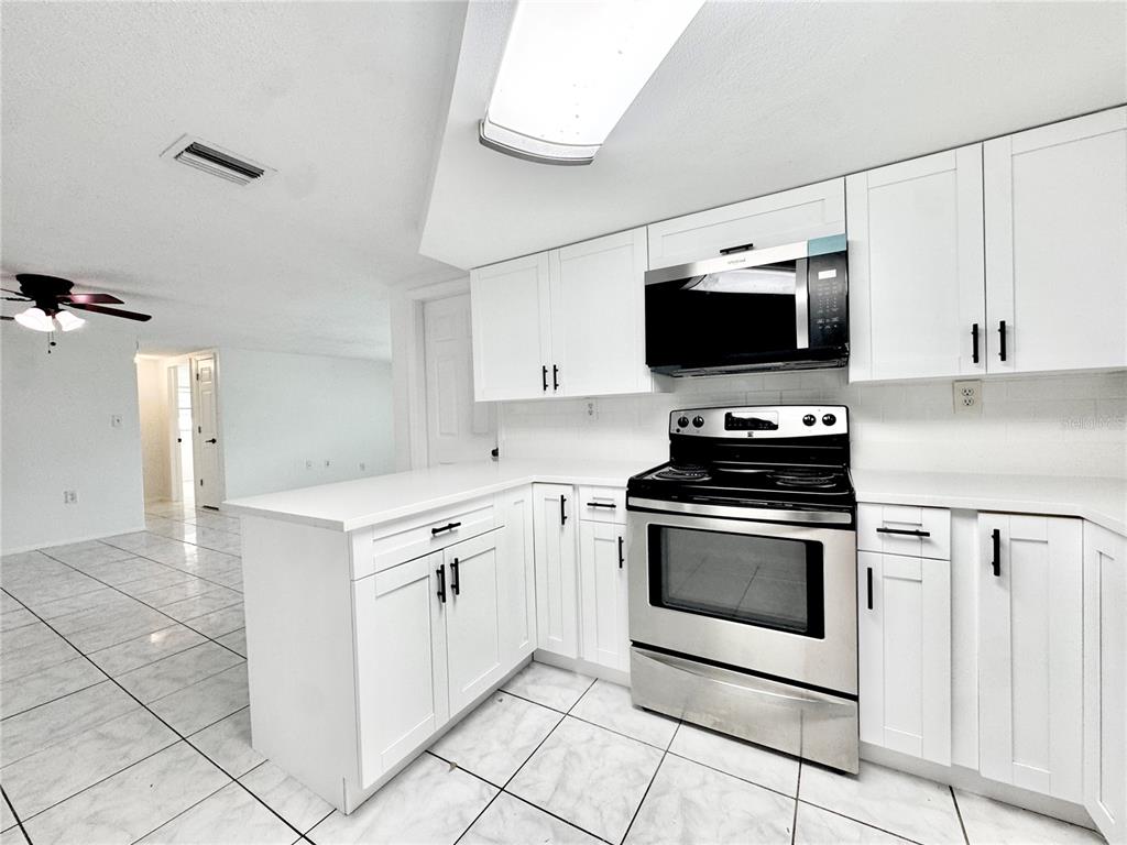 7235 Potomac Drive Port Richey, FL 34668 - Photo 7 of 23 a kitchen with a stove and a microwave