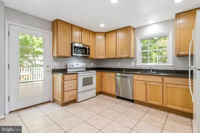 a kitchen with a sink a refrigerator and cabinets
