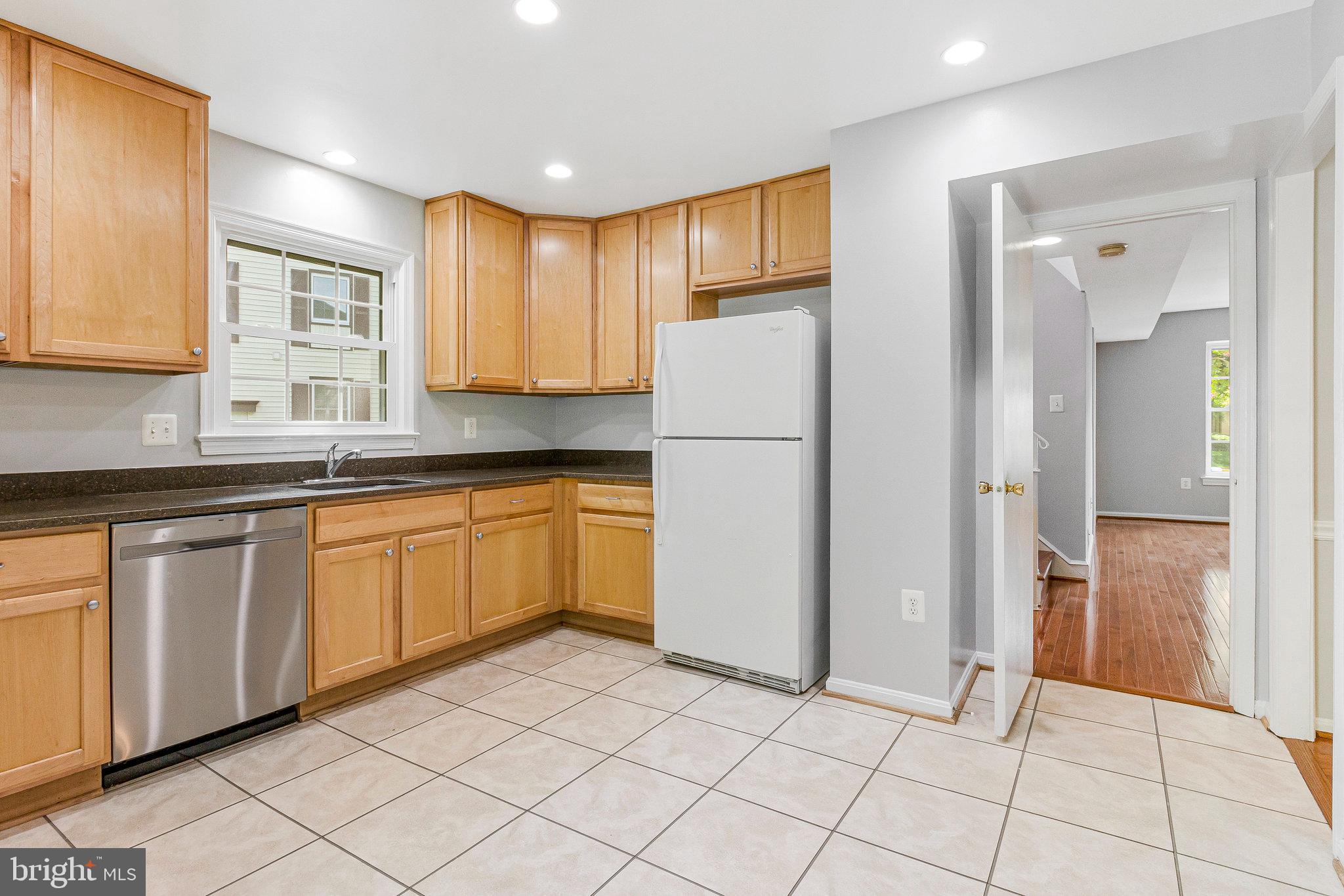 8020 Sleepy View Lane Springfield, VA 22153 - Photo 14 of 53 a kitchen with a sink a refrigerator and cabinets