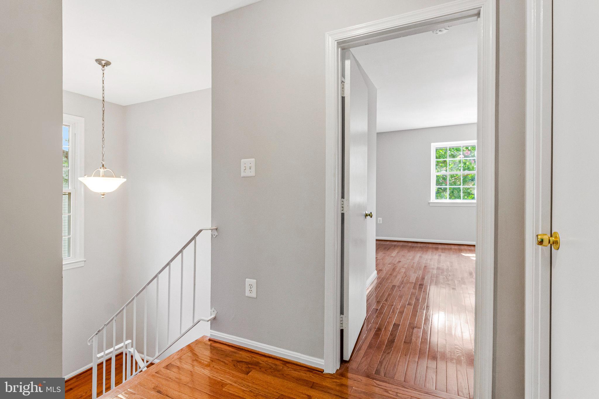 8020 Sleepy View Lane Springfield, VA 22153 - Photo 21 of 53 a view of a hallway with wooden floor and staircase