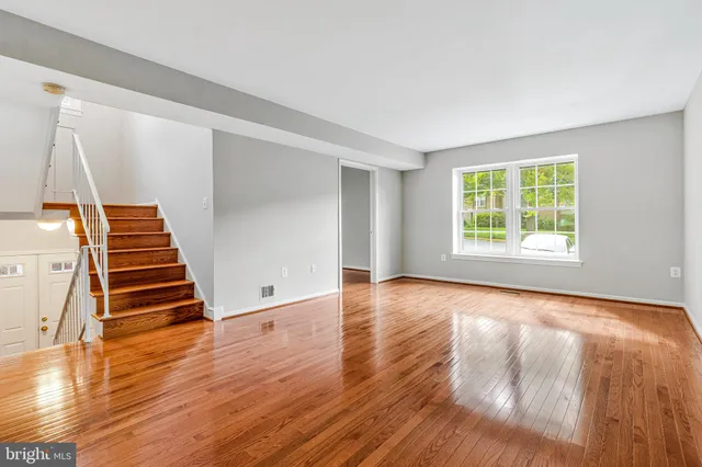a view of empty room with wooden floor and windows