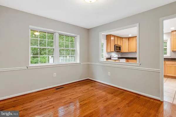 a view of a kitchen with wooden floor and electronic appliances