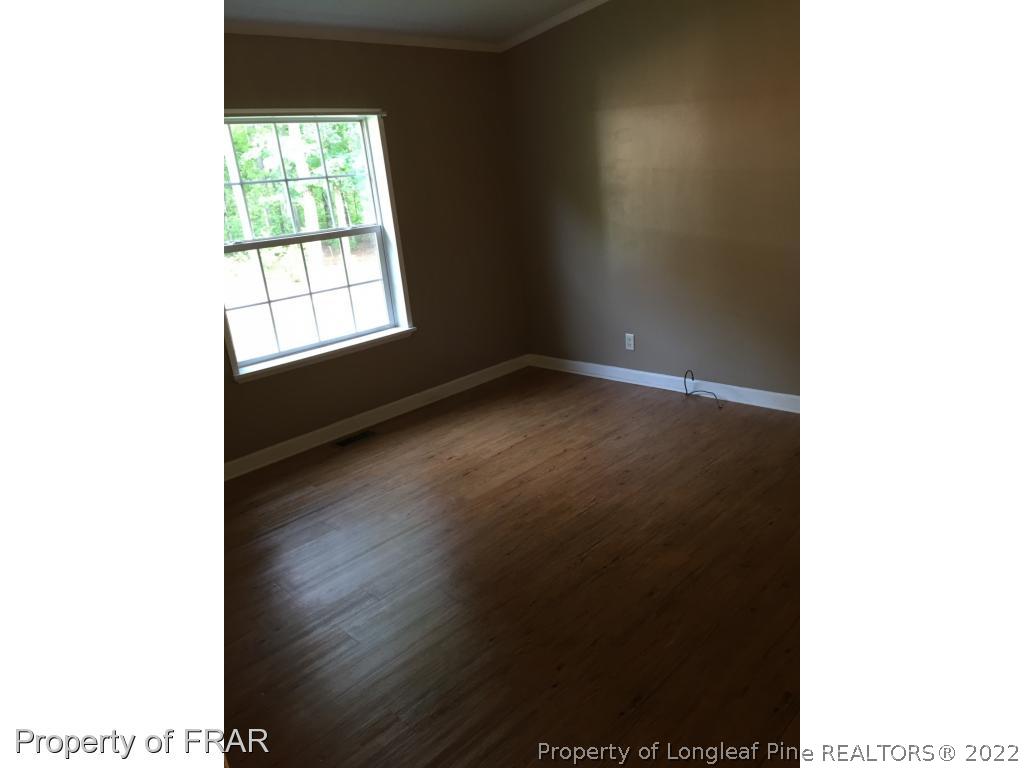 275 Deaton Road Raeford, NC 28376 - Photo 11 of 20 a view of an empty room with wooden floor and a window