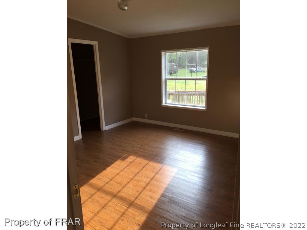 275 Deaton Road Raeford, NC 28376 - Photo 9 of 20 a view of an empty room with wooden floor and a window