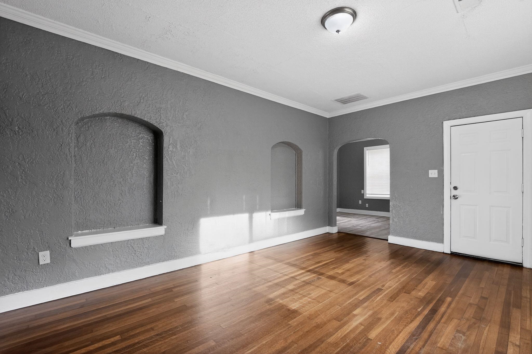 4199 Auburn Road Memphis, TN 38116 - Photo 18 of 32 Hardwood flooring throughout featuring arched wall niches, crown molding, and a paneled entry door