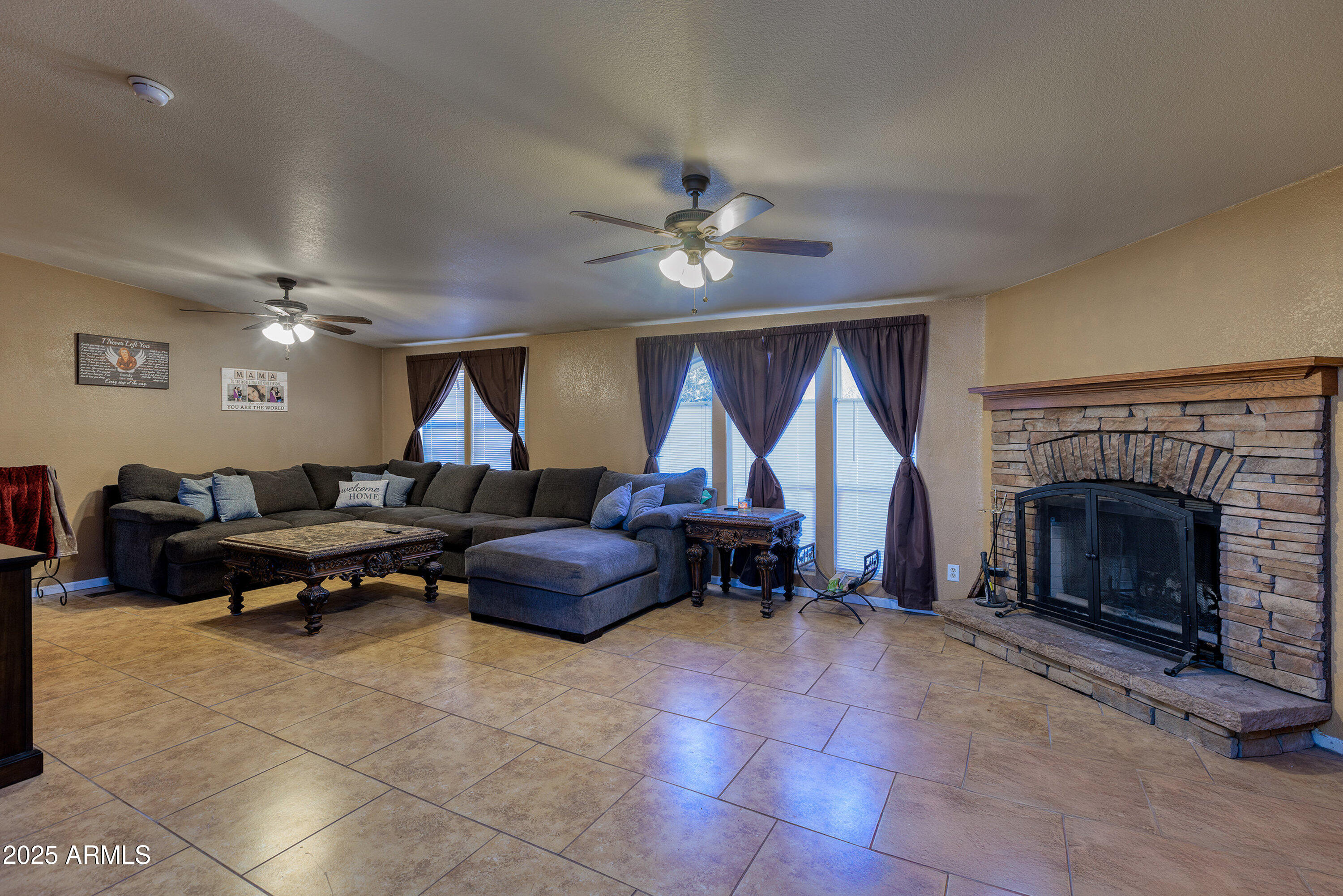 1008 West Rim View Road Payson, AZ 85541 - Photo 5 of 25 a living room with furniture a fireplace and a ceiling fan