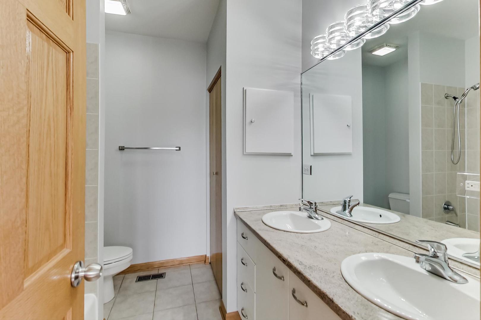 2032 West Division Street, Unit 201N Chicago, IL 60622 - Photo 14 of 18 a bathroom with a sink double vanity and a mirror