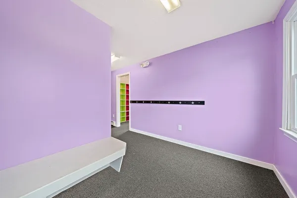 a view of an empty room with a ceiling fan and window