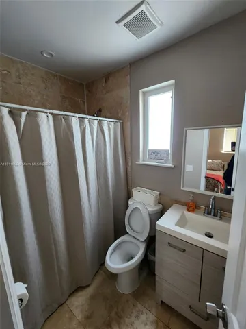 a bathroom with a toilet a sink and a mirror
