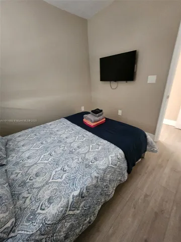 a bedroom with a bed and a flat screen tv