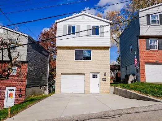 a view of a white house with a street