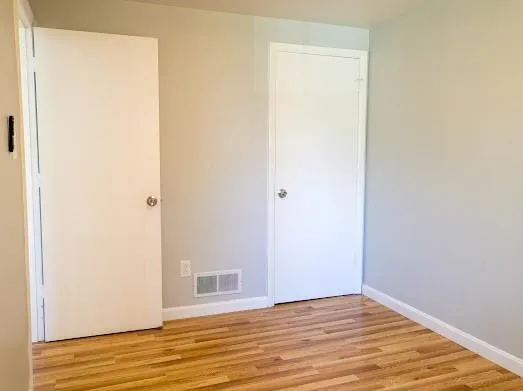 a view of a room with wooden floor