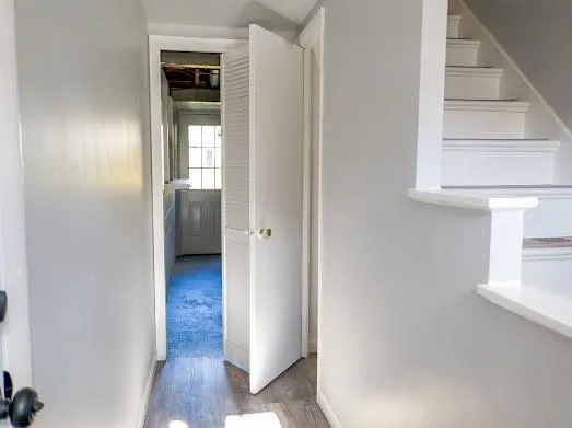 a view of a hallway with wooden floor and entryway
