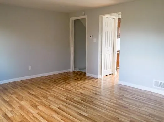 a view of empty room with wooden floor