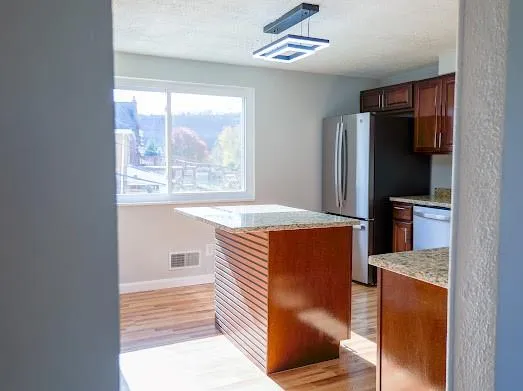 a view of kitchen with furniture refrigerator and window