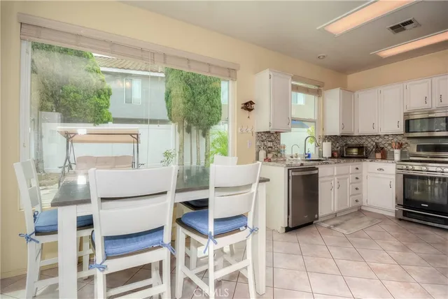 a kitchen with a stove a sink and white cabinets with wooden floors