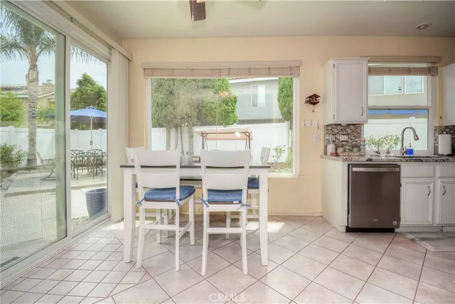 a dining room with furniture a large window and a kitchen view