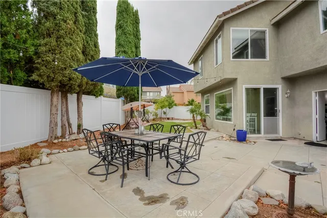 a view of patio with table and chairs under an umbrella