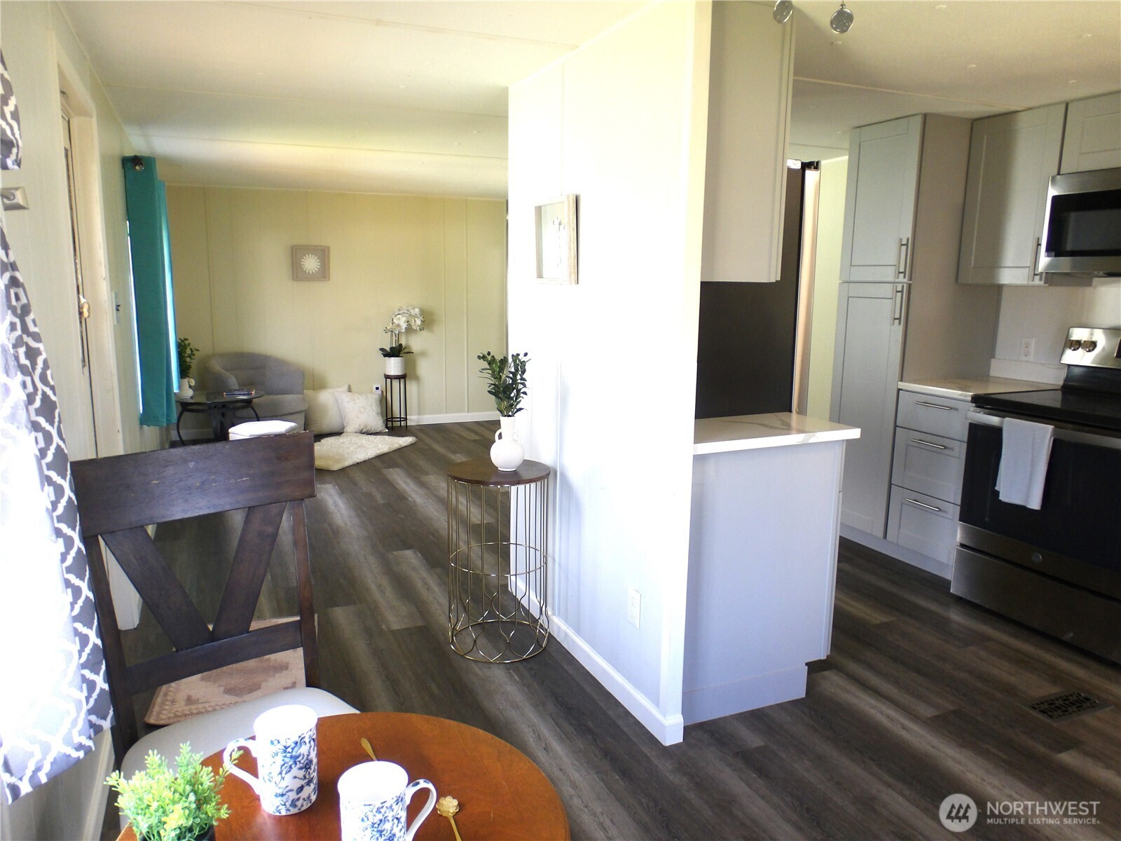 1308 263rd Place Ocean Park, WA 98640 - Photo 11 of 35 a living room with stainless steel appliances furniture a rug and a kitchen view