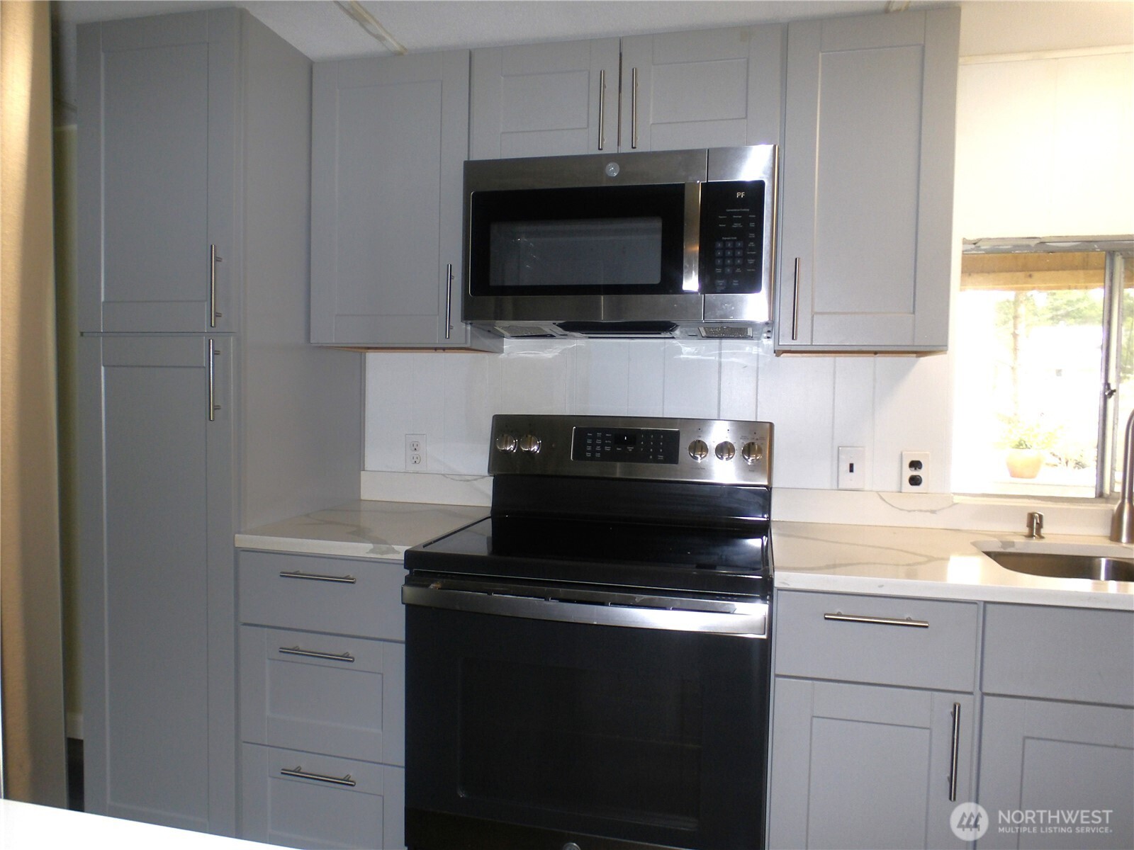 1308 263rd Place Ocean Park, WA 98640 - Photo 17 of 35 a kitchen with a stove and a microwave