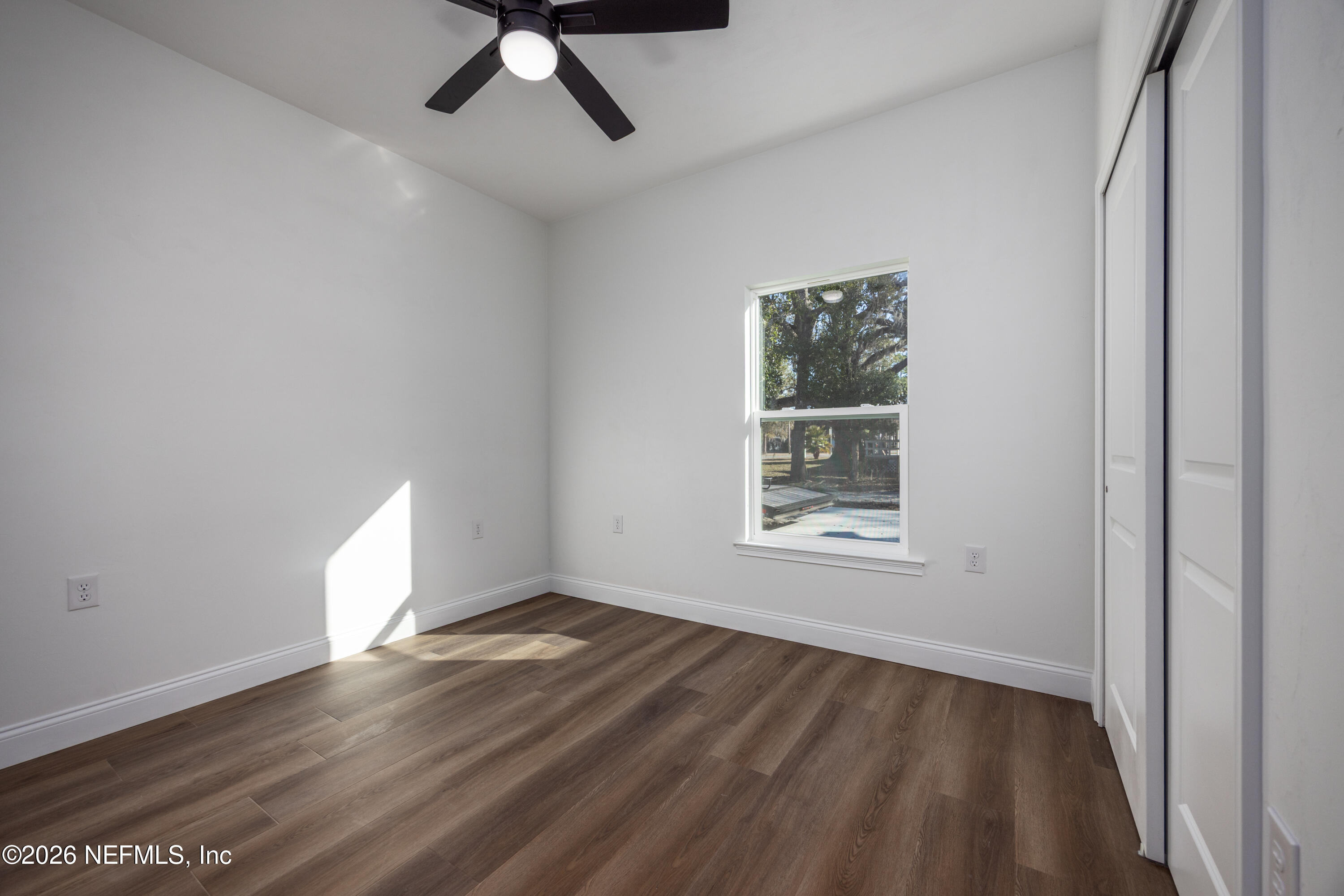 220 Southwest 3rd Street Lake Butler, FL 32054 - Photo 21 of 40 a view of an empty room with wooden floor and a window