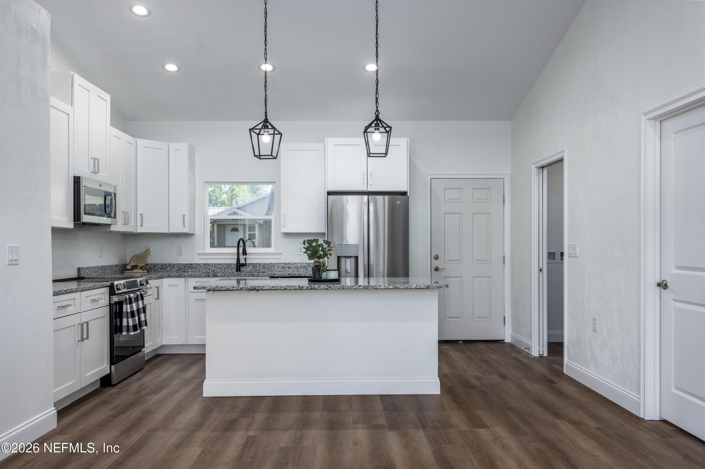 220 Southwest 3rd Street Lake Butler, FL 32054 - Photo 24 of 40 a kitchen with stainless steel appliances granite countertop a sink a stove a refrigerator and island with wooden floor
