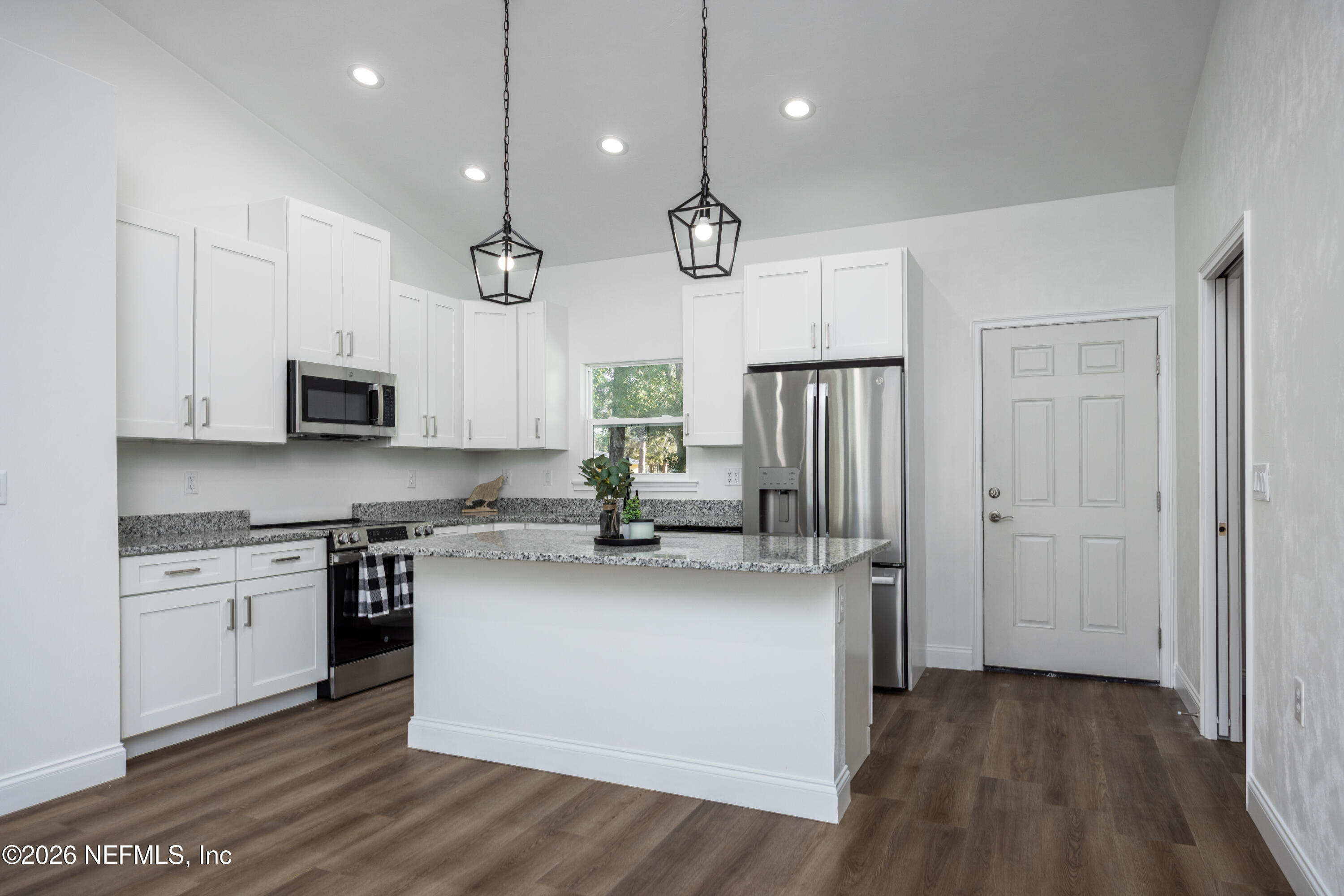 220 Southwest 3rd Street Lake Butler, FL 32054 - Photo 25 of 40 a kitchen with stainless steel appliances granite countertop a sink a stove a refrigerator cabinets and a wooden floor