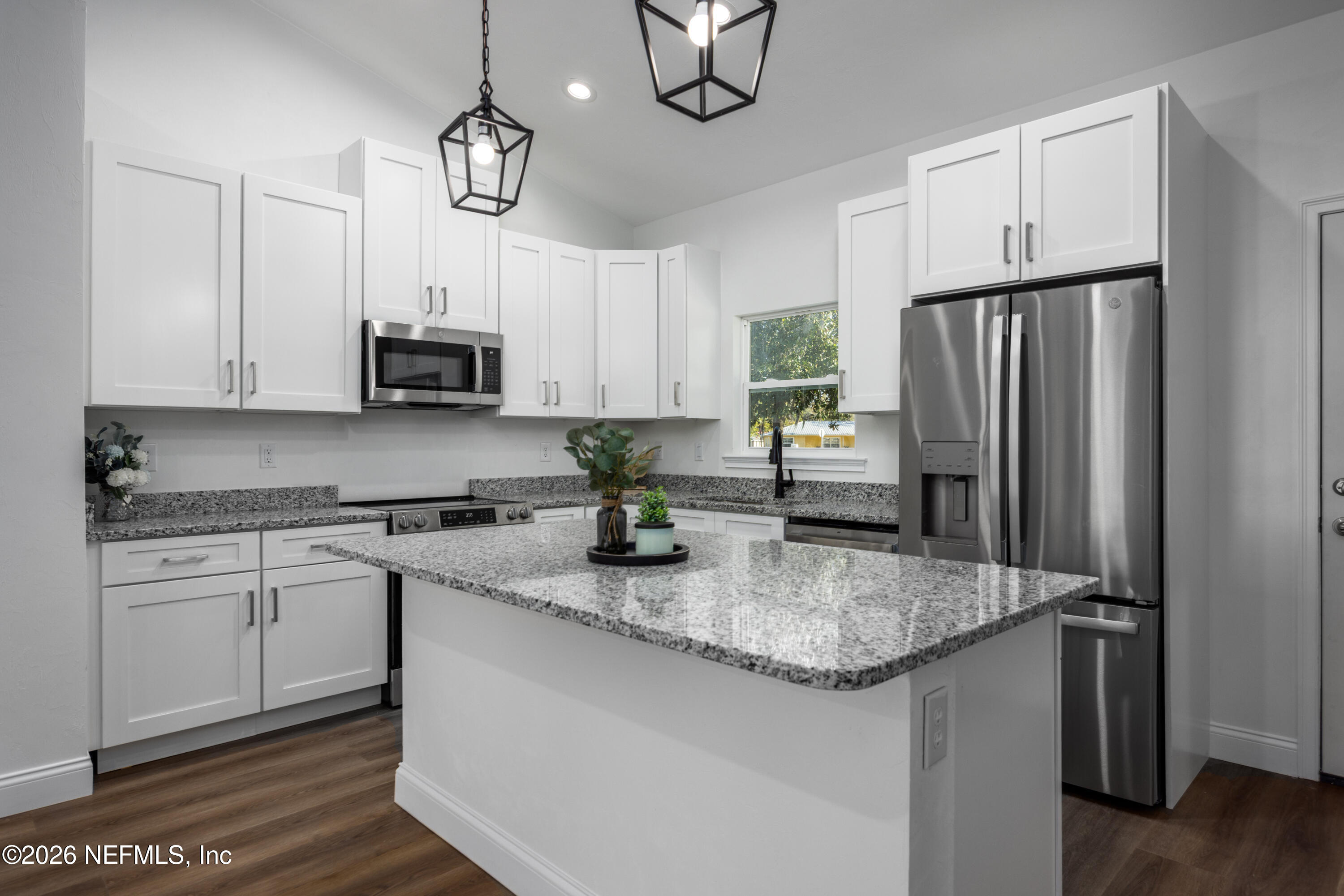 220 Southwest 3rd Street Lake Butler, FL 32054 - Photo 30 of 40 a kitchen with stainless steel appliances granite countertop a sink a stove a refrigerator a center island and cabinets