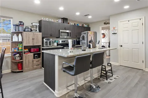 a kitchen with stainless steel appliances granite countertop a sink cabinets and wooden floor