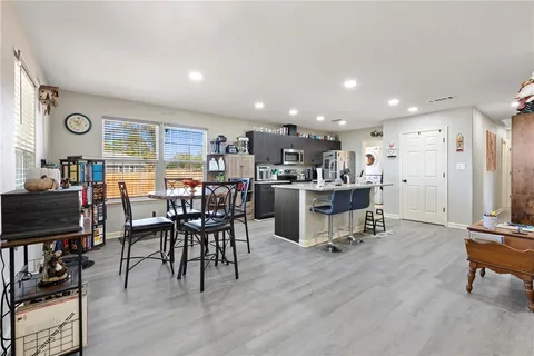 a living room with stainless steel appliances kitchen island granite countertop furniture and a large window