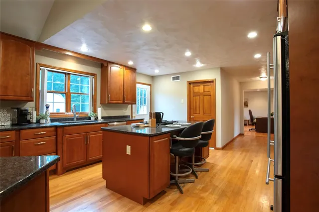 a kitchen with granite countertop sink stove and cabinets